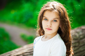 Wall Mural - Calm brunette little girl in summer park