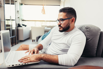 Focused man working on his laptop at home