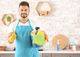 Sticker - Male janitor with cleaning supplies showing thumb-up gesture in kitchen