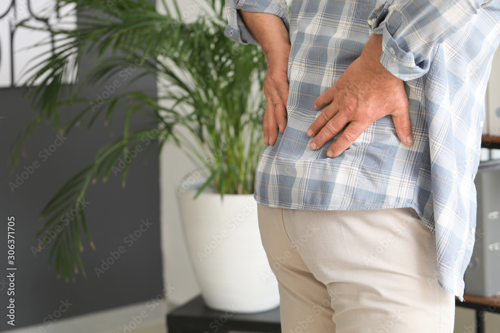 Senior man suffering from back pain at home