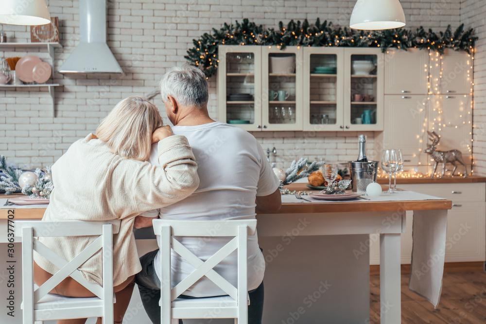 Happy mature couple on Christmas eve in kitchen