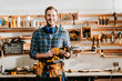 © LIGHTFIELD STUDIOS - happy bearded carpenter holding hammer drill in workshop