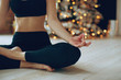 Beautiful woman practices yoga in christmas. 