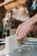 © LIGHTFIELD STUDIOS - selective focus of sawdust on hands on carpenter