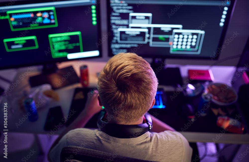 Male Teenage Hacker Sitting In Front Of Computer Screens Bypassing ...