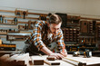 © LIGHTFIELD STUDIOS - Selective focus of woodworker measuring wooden plank
