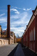 Russia, Saint Petersburg, Near Neva River, Peter And Paul Fortress: Long Narrow Alley To Famous Trubetskoy Bastion Prison With High Smokestack, Brick Walls, Cobblestone And Blue Sky - Concept Museum