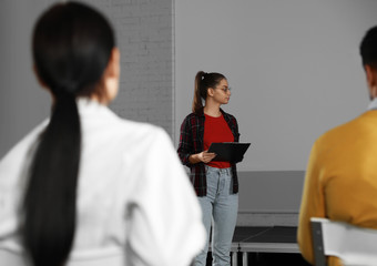 Canvas Print - Female business trainer giving lecture in conference room with projection screen