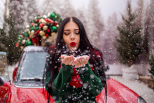 Pretty Young Girl Is Playing With Snow Near Red Car With Decorated Xmas Tree.
