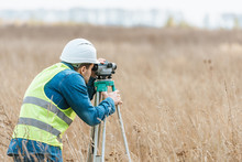 Surveyor With Digital Level Working In Field