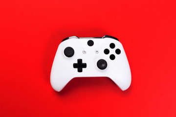 White joystick gamepad, game console isolated on red background. Computer gaming technology play competition videogame control confrontation concept. Cyberspace symbol