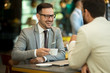 © bugarskipavle3 - Two young businessmen siting in cafe and drinking coffee while talk of the business