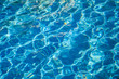 © Nikolay - Wavy blue water in an outdoor pool or fountain on a bright sunny day
