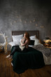 © Елизавета Старкова - Beautiful attractive sexy naked redhead girl with red lips covers herself with a pillow against the background of Christmas lighting, garlands and bokeh in her dark stylish bedroom.