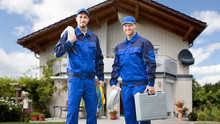 Two Male Electrician In Front Of House