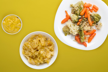  Provencal vegetables on a white plate. fried vegetables on a plate a colored background. Vegetarian food. healthy food top view