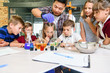 © gorynvd - Korean scientist shows to primary school pupils chemical reaction experiments at modern lab class.