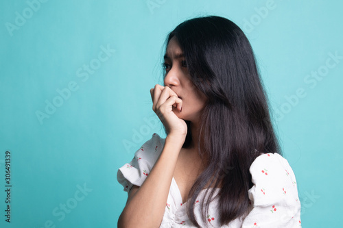 Cuadros en Lienzo Unsure hesitant nervous young asian woman biting her fingernails