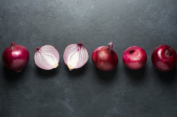 Red onion. Whole and sliced onions. Black background. Flat lay, copy space