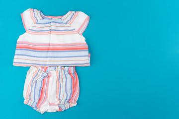 Wall Mural - baby clothes on blue  background top view