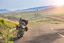 Touring Motorcycle Parking On Asphalt Road Passing Through Grassland With Sunbeams