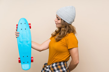 Wall Mural - Young skater blonde girl over isolated background with happy expression