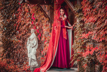 Beautiful Girl In A Burgundy Coat And Red Dress Open Door In Castle