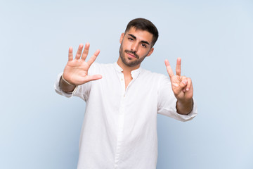 Wall Mural - Handsome man with beard over isolated blue background counting seven with fingers