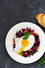 Wall Mural - Fried eggs with warm salad of red cabbage and pumpkin.