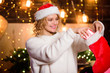 © be free - Express positivity. winter holidays decorations. Cheerful woman. girl in red santa hat. xmas stocking with presents. christmas preparation. New year present. happy new year. Gifts from santa claus