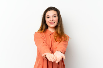 Wall Mural - Young brunette girl over isolated white background holding copyspace imaginary on the palm to insert an ad