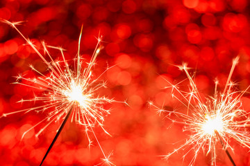 close-up of burning sparklers on beautiful bokeh background, christmas and new year festive concept