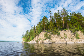 Wall Mural - panoramic view of the rocky cliff near the river kama, blue sky with white clouds.