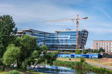 Construction site with hoisting crane and building in an environmentally friendly place