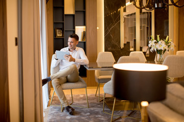 Handsome young man using digital tablet at luxury apartment