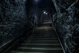 Fototapeta Uliczki - Empty lonely abandoned stairs in a rocky underground, stairway to heaven or hell