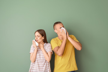 Wall Mural - Young couple suffering from allergy on color background