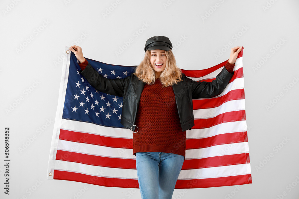 Young woman with USA flag on light background. Memorial Day celebration