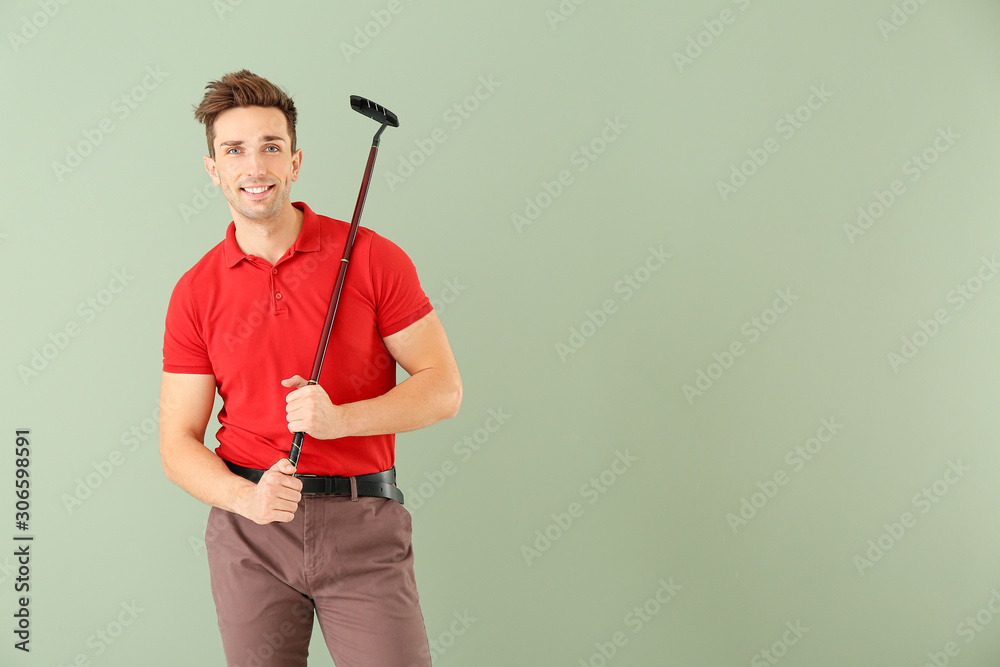 Handsome male golfer on color background