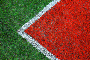 Part of empty used red tennis court playground surface with white lines closeup