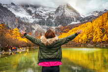 Back Side Of Asian Traveler Woman Looking And Sightseeing Over The Pearl Lake With Snow Mountain In Autumn Season In Yading Nature Reserve, China.travel And Tourism,famous Place And Landmark Concept