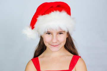 Little cute girl smiles in a santa hat