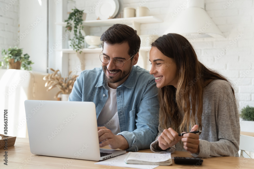 Happy young couple paying bills online in computer app - obrazy, fototapety, plakaty 