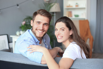 Portrait of cute young couple sitting in sofa.