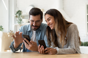 Young couple using smartphones share social media news at home