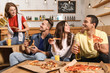 © New Africa - Group of friends having fun party with delicious pizza in cafe