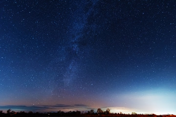 Wall Mural - a magical starry night on the river bank with a milky way in the sky and falling stars in the winter
