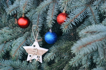 christmas toy on the branches of a new year tree. christmas tree decorated with a festive ball and w