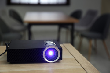 Modern video projector on wooden table in conference room