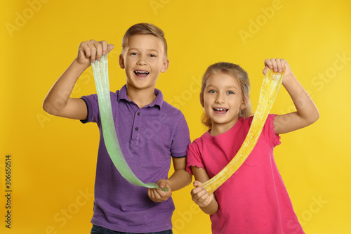 Fotografía Happy children with slime on yellow background